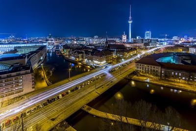 Illuminated city buildings and bridge over canal