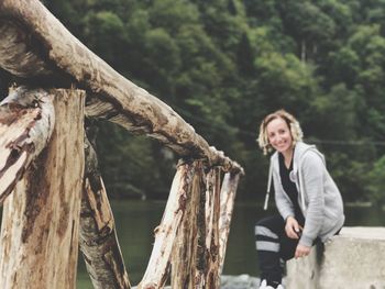 Full length of woman standing on tree trunk