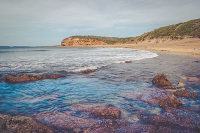 Rock formations in sea against sky