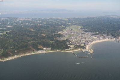 High angle view of sea by mountain against sky