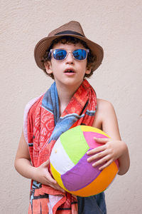 Boy wearing hat standing against wall