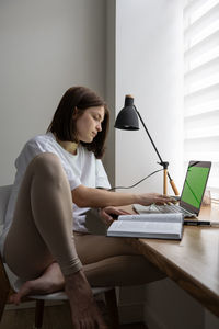 Green screen laptop and young woman with book