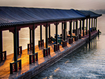 Row of built structure by sea against sky