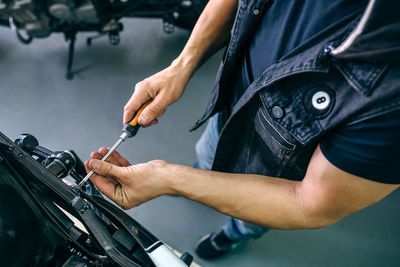 Midsection of man working on bicycle