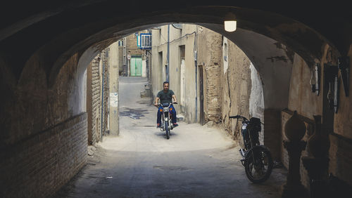 Rear view of man riding bicycle on building