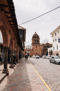 Group of people on street amidst buildings in city