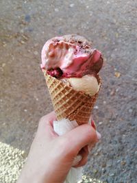 Cropped hand holding ice cream cone