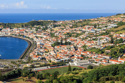 High angle view of townscape by sea against sky