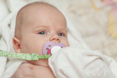 Portrait of cute baby lying on bed