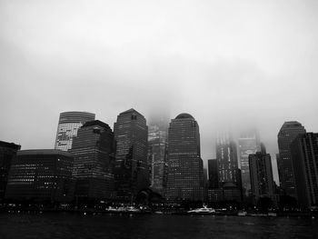 Low angle view of skyscrapers lit up against sky