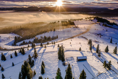 Scenic view of snow covered landscape against sky during sunset