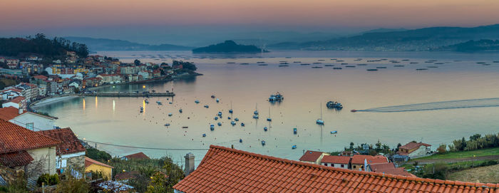 High angle view of townscape by sea against sky