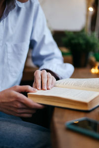 Brunette girl in a cafe drinking coffee, reading a book