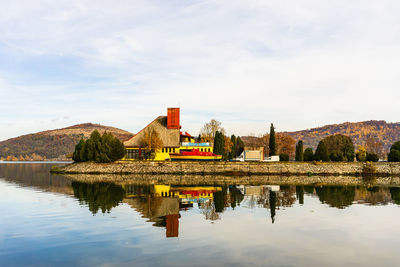 Reflection of built structure in lake against sky