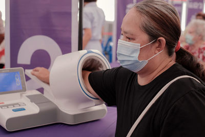 Close-up of woman wearing mask getting examined at hospital