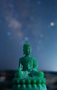 Close-up of buddha statue against sky