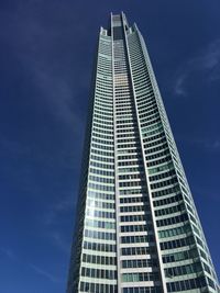 Low angle view of modern building against blue sky