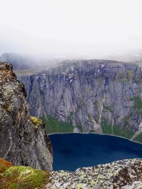 Scenic view of lake by mountain against sky