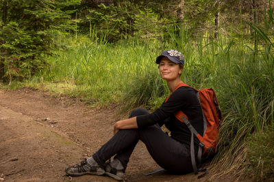 Portrait of woman sitting on land by grass