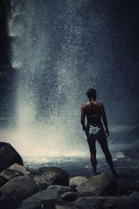 Rear view of man standing on rock