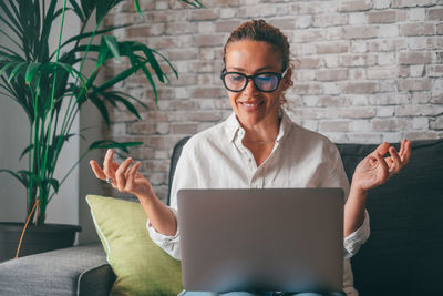 Young woman using digital tablet while sitting at home