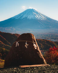 Sacred stone on a hill with mount fuji in the background in autumn time