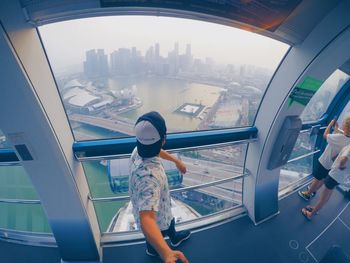 Rear view of woman looking through airplane window