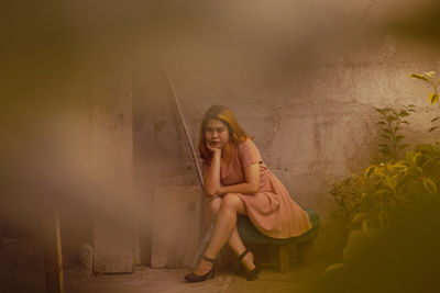 Portrait of young woman sitting outdoors