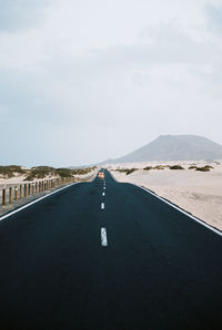 Road by mountain against sky