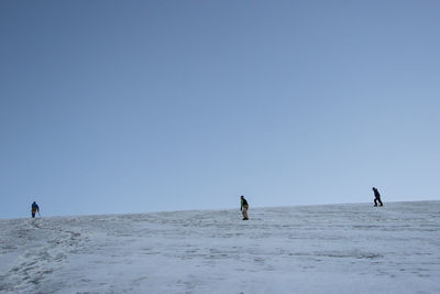 Man walking on beach against clear sky