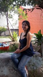 Portrait of smiling young woman sitting outdoors
