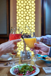 Midsection of man holding drink on table