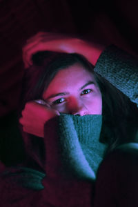 Neon portrait of a young woman sitting on book