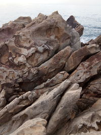 Rock formation on beach against sky