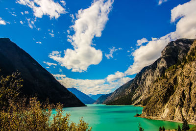 Scenic view of lake by mountains against sky