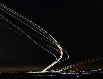 Low angle view of illuminated bridge against sky at night