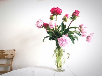 Close-up of pink flower vase against wall