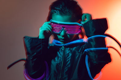 Portrait of a robot boy child from the future in neon glasses and jacket at night