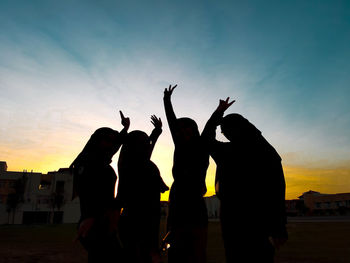 Silhouette people against sky during sunset