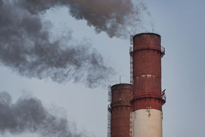 Thermal power plant pipes erupt dark smoke into the air. concept of pollution and global warming.
