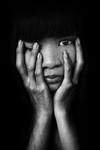 Close-up portrait of young woman in dark