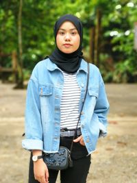 Portrait of smiling girl in hijab standing outdoors