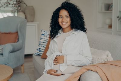 Portrait of a smiling young woman sitting at home