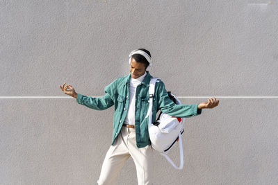 Young man looking away against wall