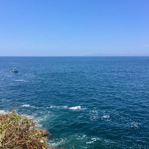 Scenic view of sea against clear blue sky