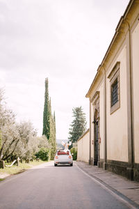 Cars on road amidst buildings against sky