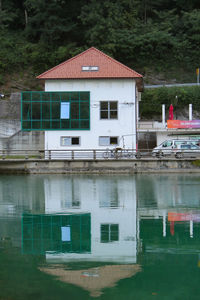 House by lake against buildings
