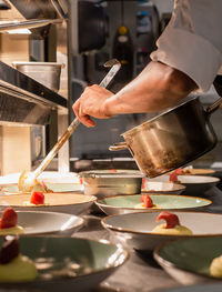 Midsection of man preparing food in kitchen