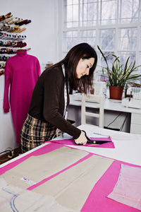 Female fashion designer tailor making sewing patterns at workplace in sewing studio. seamstress
