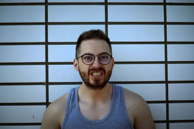 Portrait of smiling young man against wall